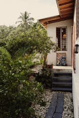 Concrete pavers lead from Azor’s back door to his backyard garden and deck. The roof’s overhang protects the home’s walls from rain.  Photo 6 of 12 in A Young Haitian Rebuilds After the Devastating Quake