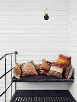 Outdoor Atop the spiral staircase, a custom iron bench is festooned with Turkish throw pillows from SophiesBazaar.  Search “montreal” from Scandinavian Style Revives This Montreal Home