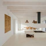 The interior showcases the roof's laminated wood beams. A Panton chair takes the seat of honor at the dining table.