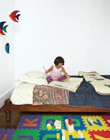 In this Brooklyn renovation, a traditional Indian twin bed in Mira’s room is outfitted in hand-stitched linens from Fabindia in Delhi. The toy blocks are from KID-O.  Photo 3 of 12 in A Minimal Yet Mighty Brooklyn Apartment