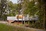 Built on a challenging hillside site and tucked behind a thicket of trees, the Bridgman, Michigan, house designed by Scott Rappe provides a modern weekend retreat for a Chicago couple. “One of my first responsibilities was getting the owners up to their house and essentially on one level. Because of the pie-shaped property, we needed to push the building up the hill to provide square footage for the program. By keeping the building perpendicular to the slope, using piloti on one side and a retaining wall on the dune side, we were able to insert foundations with minimal disturbance," says Rappe.  Search “michigan-day-2.html” from Michigan Modern: 7 Homes in the Great Lake State