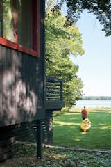 The cottage sits on an acre of mature trees, with a sloping lawn stretching to the pebbly shore of the inland lake. The Campbells regularly drag their kayaks down to the water’s edge and set off toward the deeper waters of Lake Michigan.  Photo 7 of 7 in Michigan Modern: 7 Homes in the Great Lake State by William Lamb from Campbells’ Coup