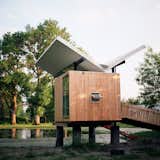 Perched above a pond on 14 acres in Champaign, Illinois, this hut was designed for enjoying tea and meditation. Dominating the 97-square-foot structure is a butterfly roof, which channels rainwater to a central spout to be directed to the pond. Adding to the zen experience are water reflections that are projected onto the soffit throughout the day.