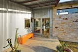 For a cost-conscious 2,000-square-foot renovation located 30 minutes outside of Austin, Texas, architect Nick Deaver took a look around for inspiration. He spied galvanized metal cladding on the region’s sheds and co-opted the inexpensive, resilient material for his own design. He then applied locally quarried Lueders limestone near the entrance—a warm contrast to the steely facade.