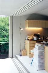 Custom-made paulownia cabinets and a roomy balcony keep the compact second-floor living-dining-kitchen area from feeling cramped or cluttered.  Photo 5 of 10 in More Tiny Kitchens We Love by Erika Heet from Small Space Live/Work Box Home in Japan
