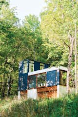Set in the lush Wisconsin forest, this neatly stacked cabin was built vertically in order to minimize the amount of grading and landscaping necessary for construction. Photo by: Narayan Mahon