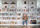 Living Room, Bookcase, Concrete Floor, and Stools In the living area, Brothers sits on an Artek stool while perusing a selection from his library.  Search “kaktus-stool-by-enrico-bressan.html” from Idyllic Home Designed for an Artist