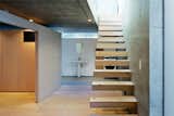 Staircase and Wood Tread The staircase leads to the living area upstairs.  Photo 9 of 29 in Reference by Muhammad Suryo Aji Riyanto from Open-Plan Concrete Home in Japan
