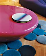The bright pink Smarties table by Mattia Bonetti is surounded by designs by the Bouroullec brothers—a lacquered steel table center and blue rug.