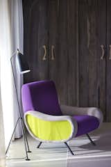 Suites are adorned with armchairs by Zanusso in two custom colorways: orange, grey, and purple; and apple green, grey, and purple. Black and white photos by Romain Mallet on the walls pull the palette together.