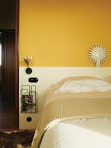 Bedroom, Bed, and Wall Lighting Farrow & Ball’s Babouche yellow enlivens one of the bedrooms.  Photo 1 of 25 in 25 Playful Homes Splashed With Vibrant Pops of Yellow from Modern Home Furnished With Flea Market Finds
