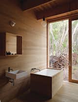 Houle designed the ofuro tub in the master bath to mesh with the home’s tallowwood wall paneling. The Ikea sink is outfitted with Vola faucets.