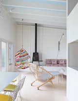 Alexandra Angle transformed a beachside cabin into a colorful retreat for a college friend and her family. The living area features a PP130 Circle Chair by Hans Wegner and a Shaker wood stove by Antonio Citterio with Toan Nguyen for Wittus. A Tropicalia Cocoon hanging chair by Patricia Urquiola complements the fabric from Liberty that Angle used for the cushions on the built-in banquette.