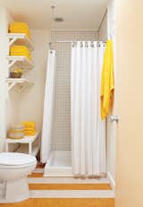 In the guest bathroom, a set of Senegalese nesting baskets mirrors the yellow-and-white pattern on the linoleum floor.