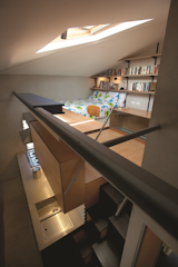 The lofted room is adorned with inexpensive features, such as a wall of Spur shelving with aluminum brackets.  Photo 6 of 10 in Compact Australian Home Clad in Steel and Concrete