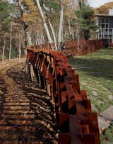 Landscape architect and artist Mikyoung Kim created a Cor-ten steel fence to enclose a three-acre site in Lincoln, Massachusetts. "The entire fence is made using just seven lengths of modular, precut Cor-Ten steel bars, with widths being anywhere from two to five bars thick," explains the designer. "Depending on the angle from which you see it, the fence can appear transparent or opaque."&nbsp;