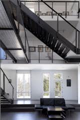 Natural light floods the interior and a network of metal stairs—reminiscent of an MC Escher drawing—is suspended overhead. The interior palette is white, black, and gray—the owners favorite colors.