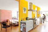 Kitchen, White Cabinet, Range, Range Hood, and Marble Counter How a highly productive collaboration among a trio of creative Angelenas—and a good dose of Barragán—turned a dark and beleaguered midcentury house into a family home for the ages. The resulting design acquired its own flow, full of colorful narrative, spirited counterpoint, and anecdote. Now, in place of dark, disconnected spaces, outdoor rooms echo luminous indoor ones, and experimental filmmaker Laura Purdy and her family’s eclectic collections of art and personal artifacts share space with flashes of pattern and interior planes of saffron and pink stucco.   Photo 7 of 12 in The Year in Review: Dwell's Top 12 Homes of 2012 by Diana Budds from A Fresh Dose of Color Livens Up This Midcentury Los Angeles Home