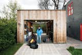 At a laid-back home in Bozeman, Montana, homeowner Brian Whitlock clad his tool shed with rustic wood. Two garage doors roll up for maximum flexibility from front to back, and simple light fixtures on the exterior are practical but also in keeping with the structure's design.