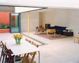 The glass wall separating the main living area and the inner courtyard garden opens like an accordion to create a barrier-free transition. Built-in planters along the walls of the courtyard add greenery without eating into the valuable surface 

area of the courtyard.  Photo 5 of 12 in Clean and Contemporary Interiors  by Jami Smith from A Slender Geothermal Cottage in London