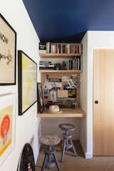 The bedroom allows for a tiny niche for a built-in wood desk. The target painting is by Alia Penner.
