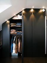 The apartment's built-in closets are deep and have mirrors on one side. Spotlights set flush overhead provide light and also allow the maximum amount of storage, all the way to the ceiling. For more of Schönning's dark, cozy-meets-modern interiors, visit his website. Photo by Per Magnus Persson.