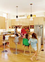 Kitchen, Wood Cabinet, and Pendant Lighting Gliss swivel stools and a Dowel bar stool share space in front of a custom maple kitchen island. The pendant lamps are by Lightolier.  Photo 3 of 11 in Modular Compound is the Ultimate Retreat for Three Generations