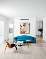 Living Room, Chair, Sofa, Light Hardwood Floor, and Coffee Tables They collaborated on the project with investor and landowner Holden Shannon whose own home on the Row was outfitted by designer Barbara Hill with vintage furniture like a turquoise sofa and pair of mid-century side tables from Houston’s Reeves Antiques.  Photo 12 of 25 in Modern Interiors (White) by Shahdia Jamaldeen from Row on 25th: Affordable Housing Development in Houston