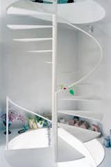 A steel spiral staircase efficiently links all three floors. With no interior doors, Yurika can keep an ear on the shop from upstairs while maintaining the privacy of her home with the help of the vertical distance.