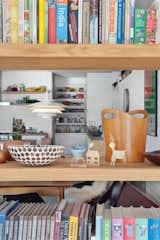 Open shelving between the living room and dining area maximizes light and air flow and showcases eclectic objects, which include old printing blocks found at a garage sale and bowls Tyler’s mother bought in South Africa.