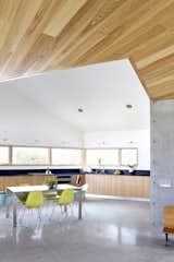 From the entrance, you can see the home's kitchen underneath the wraparound cypress ceiling. The modular kitchen system is by Viola Park. Paperstone countertops are made of recycled material—more cost effective than the traditional stone or quartz.