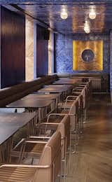 Custom oak, metal, and leather furniture is inlaid with brass detailing.  Photo 3 of 5 in Restaurant Channels Modern Istanbul in the Heart of London by Allie Weiss