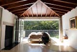 With a gentle nudge, architect John Senhauser pushes a custom bed outside onto the terrace. The bed travels along a metal track set into the white-oak floor. The ceiling rafters are Douglas fir.
