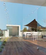 With a fire pit, mobile shades, and drought-tolerant grasses recessed in the Mangaris plank expanse, the roof deck is a communal space in the duplex. The Kookaburra Shade Sail, made of a woven polymer material that prevents mold, can be moved around as needed.