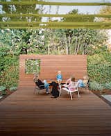 An ipe deck slopes sharply skyward behind Amy Persin’s house in Menlo Park, California, creating a secluded backyard getaway that feels like an outdoor extension of her living room. A single step on either side leads to patches of gravel, which her children have claimed as areas for unstructured play.