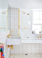 In a Melbourne home, gold fixtures and white subway tile mix in the bathroom.