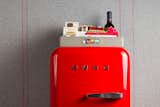 A bright red mini-fridge by Smeg reinforces the Virgin branding in each room.