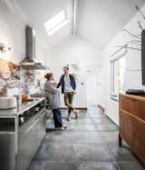 By introducing chic new elements, a Belgian couple takes a gentle approach to transforming a tired house into a vibrant workshop. Homeowners Michaël Verheyden and Saartje Vereecke were undaunted by the prospect of renovating their crumbling 1930s brick house on a tight budget. For the new kitchen, they incorporated a Smeg cooktop, oven, and range hood, stainless steel cabinets from Habitat, and personal accessories like a prototype goblet.