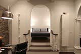 A deep proportional arch opens to the elevated bedroom which features bi-directional beamed ceilings, knee walls, and sloped ceilings. Photo by Brittany L. Kimmel.