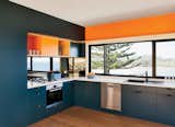 Inspired by the sea and sand, the couple chose blue and orange joinery colors. The oven, cooktop, range hood, and dishwasher are by Bosch.