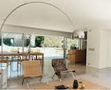A 14-foot-wide opening at the rear of the house contributes, along with the concrete flooring, to an almost seamless transition from indoors to the patio. A spate of mid-century furnishings includes chairs by Hans Wegner and Poul Kjærholm and an Achille Castiglioni Arco lamp.