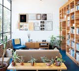 Living Room, Bookcase, Shelves, Pendant Lighting, Sofa, Chair, Media Cabinet, End Tables, Bench, and Linoleum Floor The picture wall is adorned with images collected from family, colleagues, and estate sales. ”I kill plants, so cacti are our friends,” Peter says of the succulents along the low table behind the Design Within Reach sofa, just over which an Established & Sons Font clock keeps time.  Photo 1 of 1 in lounge by Kent Hislop from Storage Savvy Renovation in Emeryville