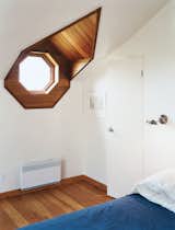 At a wood-clad house built in 1915 on a remote fishing island in Quebec, Canada, a modern renovation by YH2 melds the local vernacular with contemporary flair. The octagonal porthole window is not uncommon in older homes, but its presence is a pleasant surprise in the master bedroom, where it not only evokes the sea, but also looks out onto it.