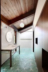 In a sophisticated main bathroom in Seattle, sea-green concrete floor tiles with a geometric pattern provide a lawn of color against wood walls and white tile. The paper lanterns are also a clear homage to the building’s Japanese inspirations.