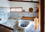 Bath Room and Mosaic Tile Wall The sunken bathtub in George Nakashima’s Sanso Villa mimics the shape of a swimming pool on the grounds. His daughter, Mira Nakashima, took over the studio after his death and now lives and works on the property. “A Japanese garden often has a central pond derived from the character for ‘heart’ or ‘spirit,’ and this may be an abstraction of that character,” she says of the tub’s sculptural form.  alexandra wilding’s Saves from A Serene Nakashima Bathroom Survives