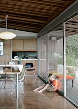 Dining Room, Table, Chair, Pendant Lighting, and Concrete Floor Luke channels Jimi on the concrete floor of the open living and dining room.  Photo 3 of 11 in Living Room by Takeshi Ideyama from Oakland Aesthetics