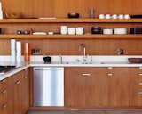 The kitchen cabinetry, custom designed by the architects, is smooth brown teak. The faucet is by Hansgrohe, and the dishwasher is by Bosch.