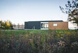 The facade is a mix of finished-wood siding and copper-hued aluminum.