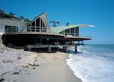 White paint now covers the exterior walls of the Cooper Wave house, and the beach has shrunk over the decades since the house was built (1957–59), which has forced the current owners to construct new supports in the form of massive concrete caissons now visible below the deck. Despite the changes, the original concept of the three dynamic vaults, or “waves,” of the roofline still resonates.

Photo by Juergen Nogai  Photo 3 of 7 in Stunning Homes Perched High Above the Pacific Ocean by Brandi Andres from Incredible Rooflines