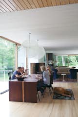 Light Hardwood Floor, Table, Pendant Lighting, and Dining Room The family relaxes in their home’s dining 

room, sited atop the old foundation. Organschi designed and fabricated the table of wenge wood; the chairs were inherited from his uncle; and the pendant lights are Bertjan 

Pot designs for Moooi.  Search “vintage-design-on-a-dime.html” from Gable-Roofed Rural Weekend Home in Connecticut